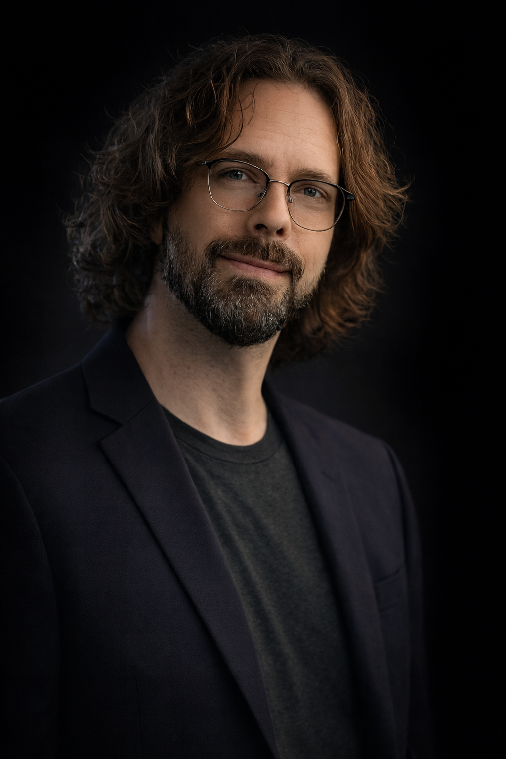 Erik Cadieux — AI integration specialist. Professional portrait, dark studio background, glasses, warm expression.